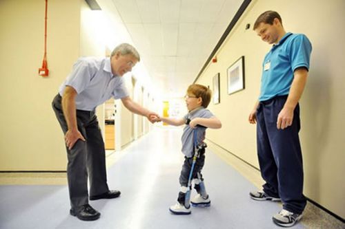 Picture of 6 year old Aiden Kennedy using hi
s reciprocal gait walking device to walk