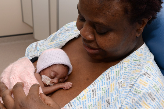 Photo of a mother with her baby giving kangaroo care (holding skin to skin)